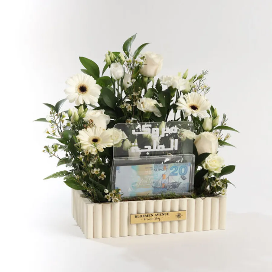M42 A wooden box of White flowers and includes an empty money box with the words " Mabrouk Al melga "